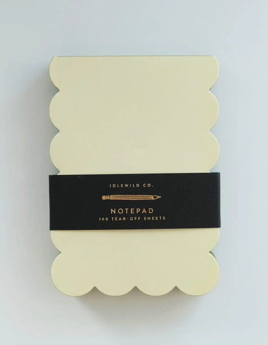 Notepad with scalloped edges and a black label on a light gray background