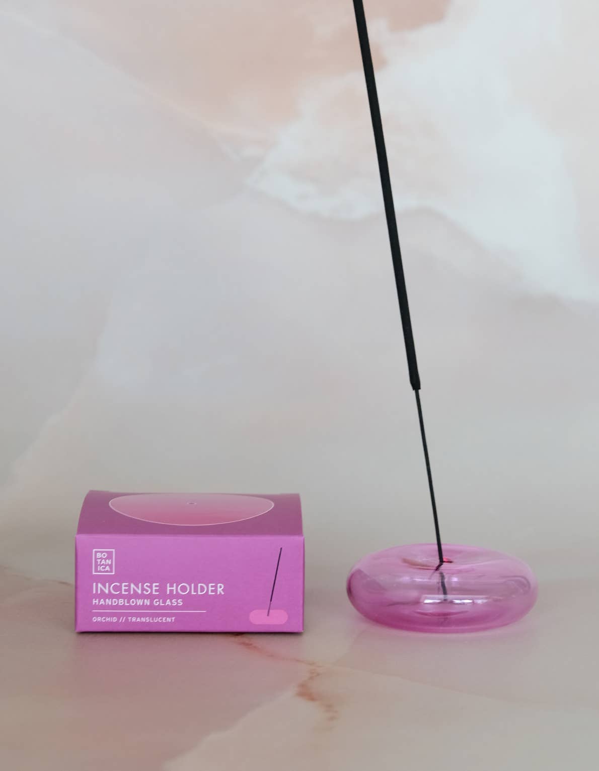 Bubble glass incense holder styled on a surface