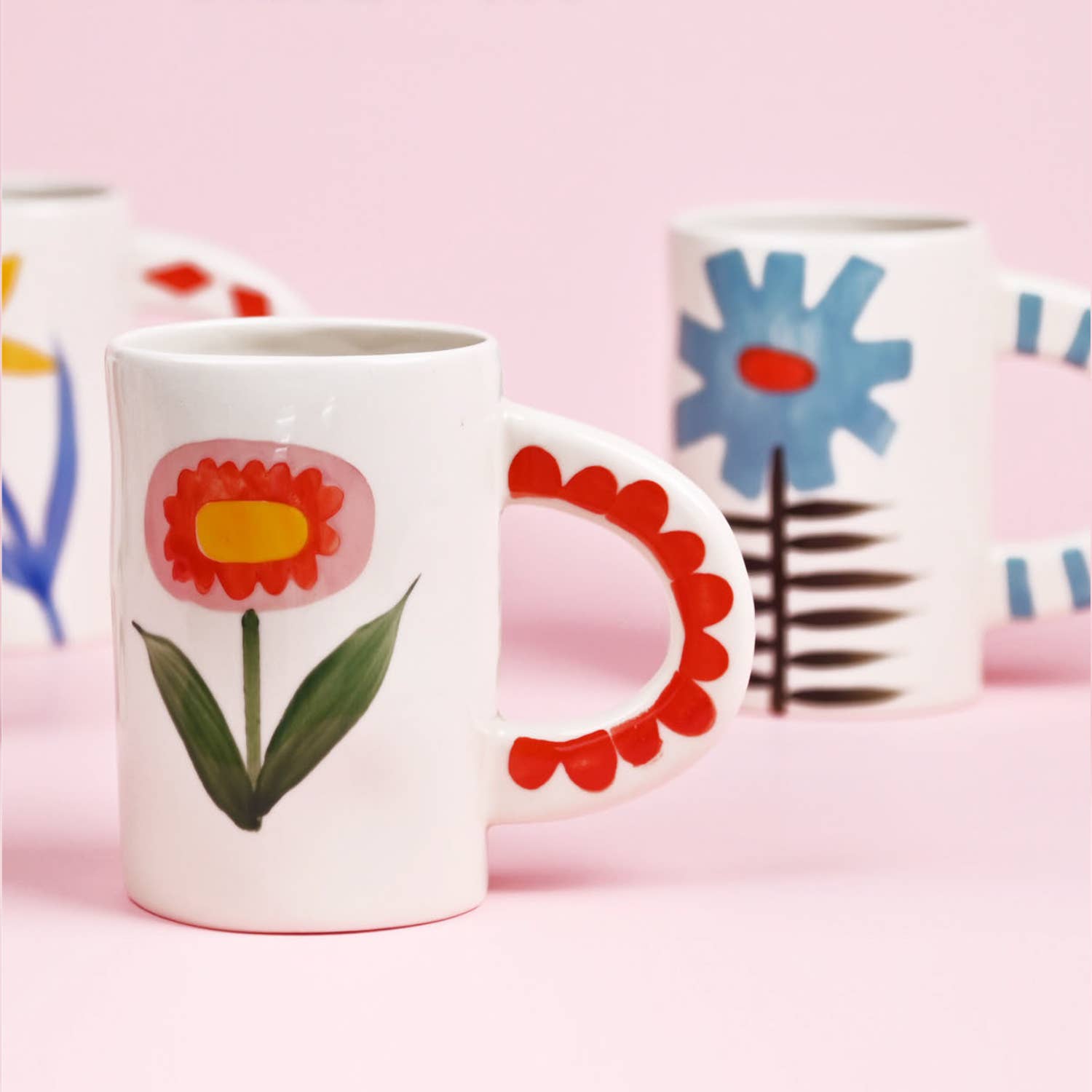 Mugs with floral designs on a pink background