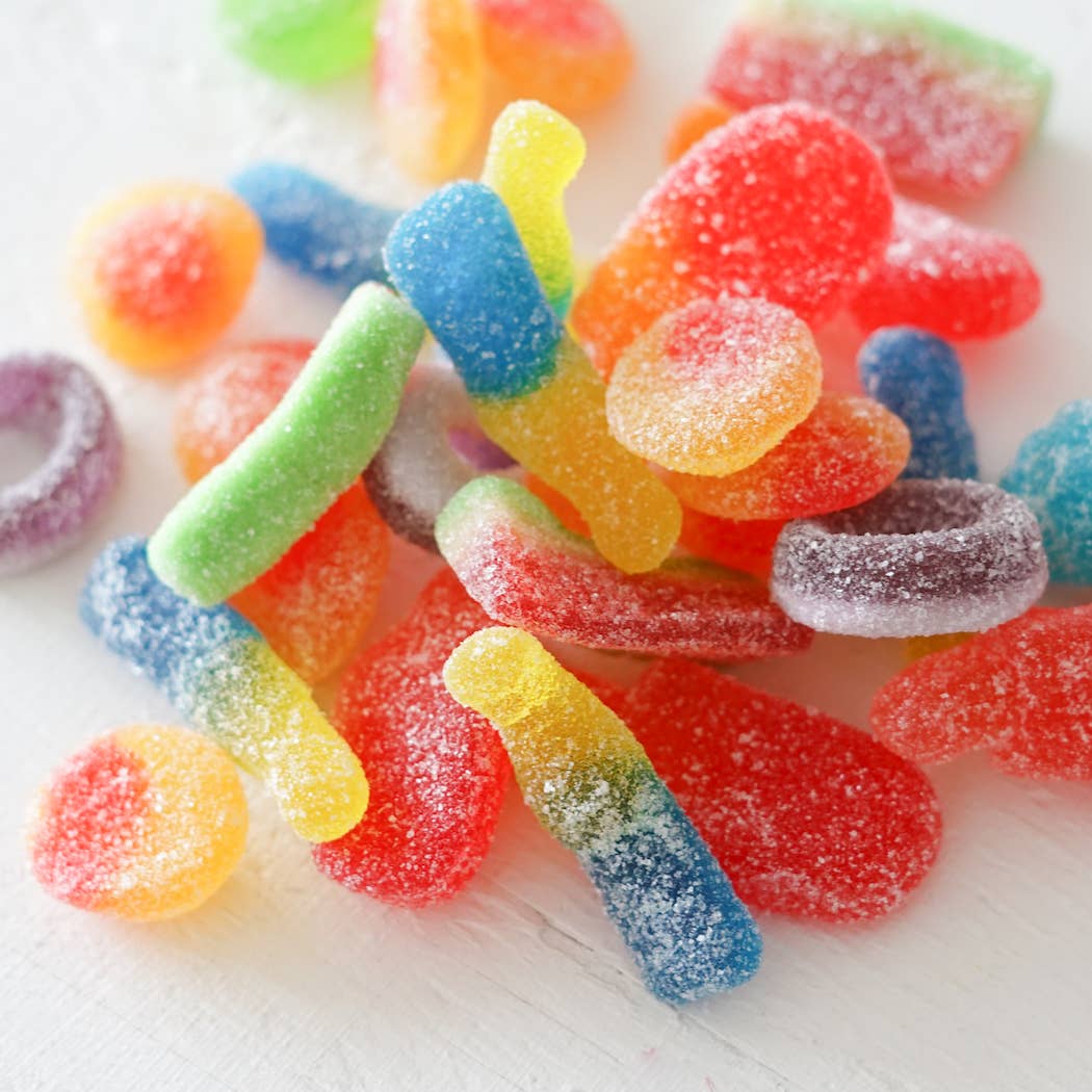 Colorful gummy worms on a white surface