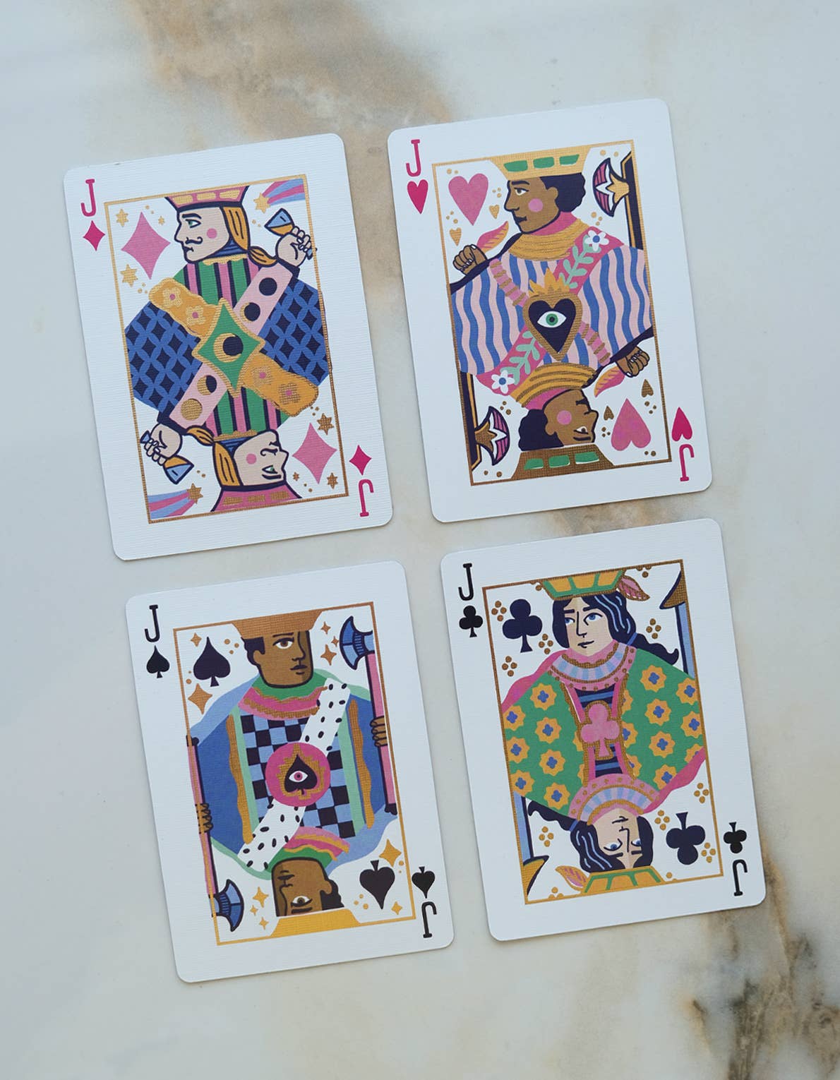 Four playing cards with different suits on a light background