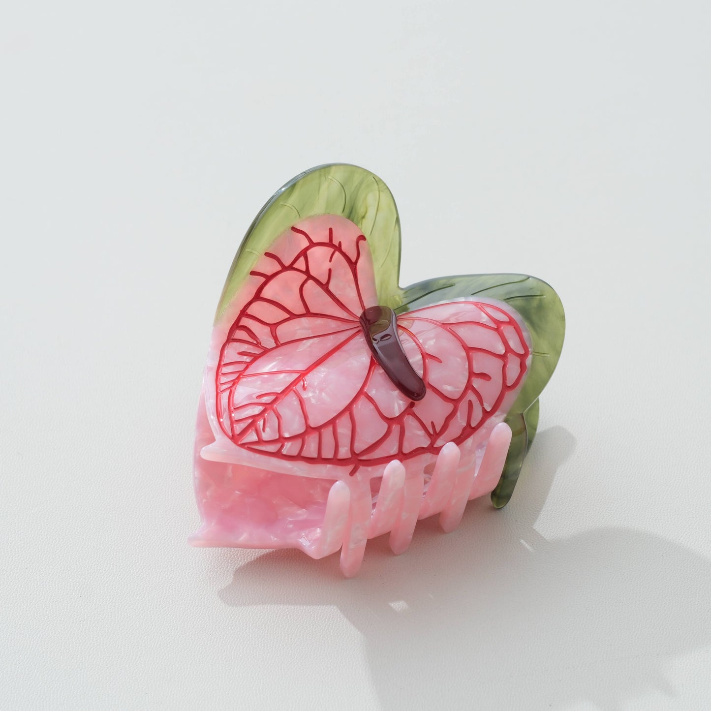 Pink and green anthurium-flower claw hair clip on a white background