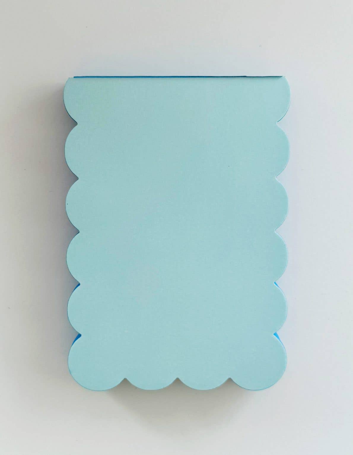 Light blue scalloped notebook on a white background