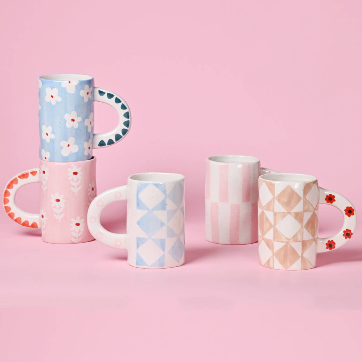 Set of patterned mugs on a pink background