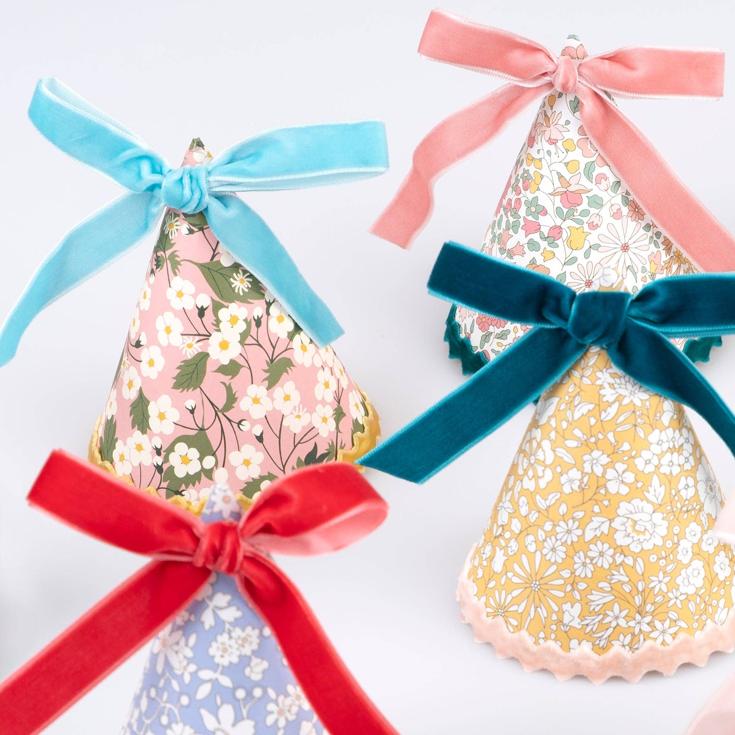 Assorted Liberty floral prints across the set of eight party hats
