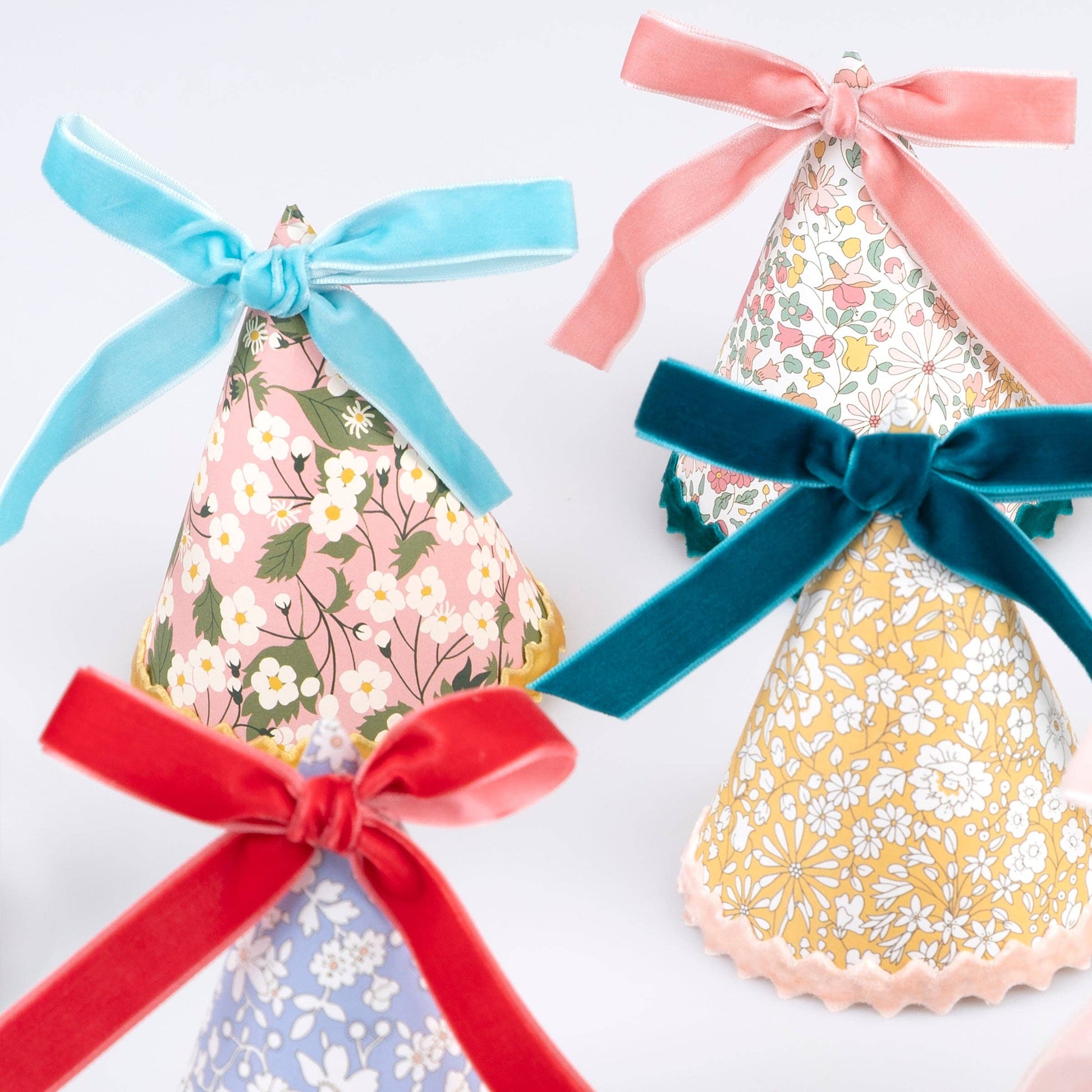 Assorted Liberty floral prints across the set of eight party hats