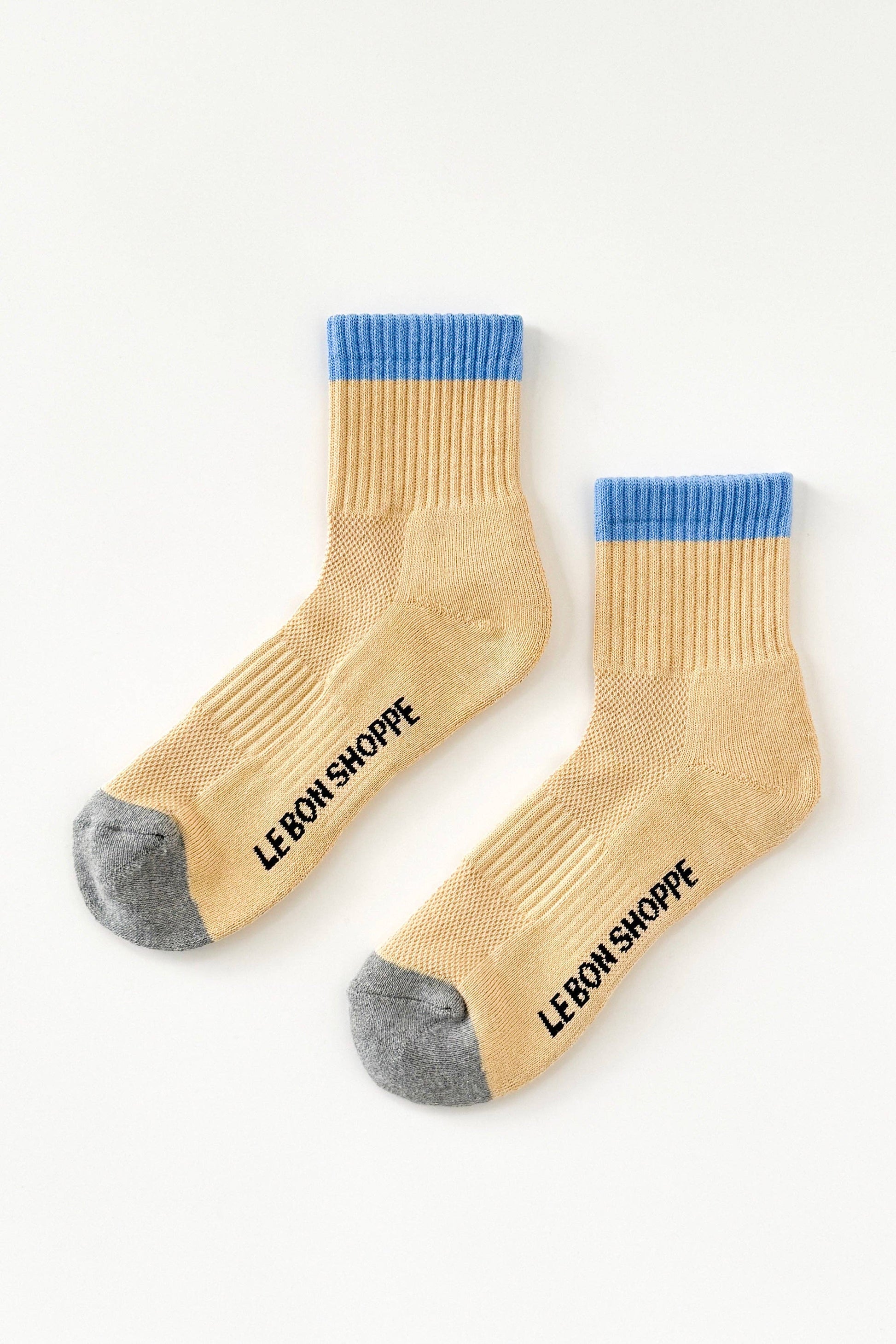 Beige socks with blue tops and gray toes on a white background, featuring 'Le Bon Shoppe' branding.