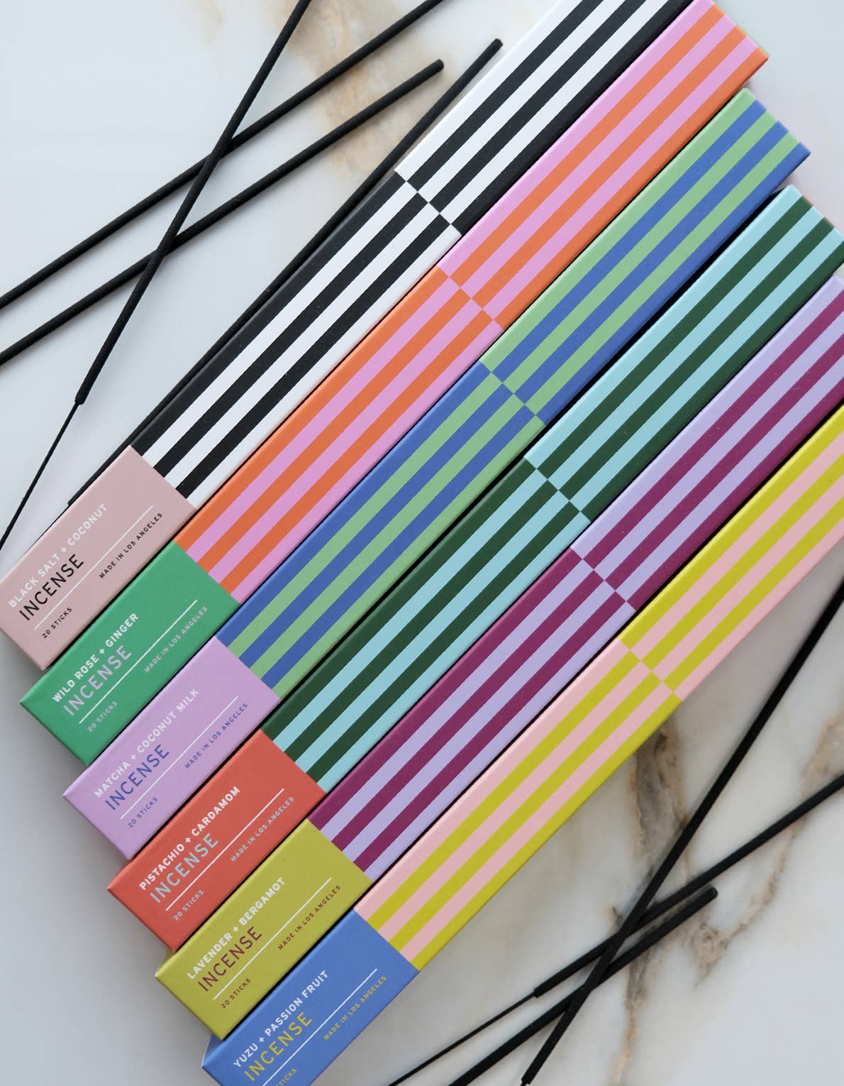 Lit incense stick with a wisp of rising smoke