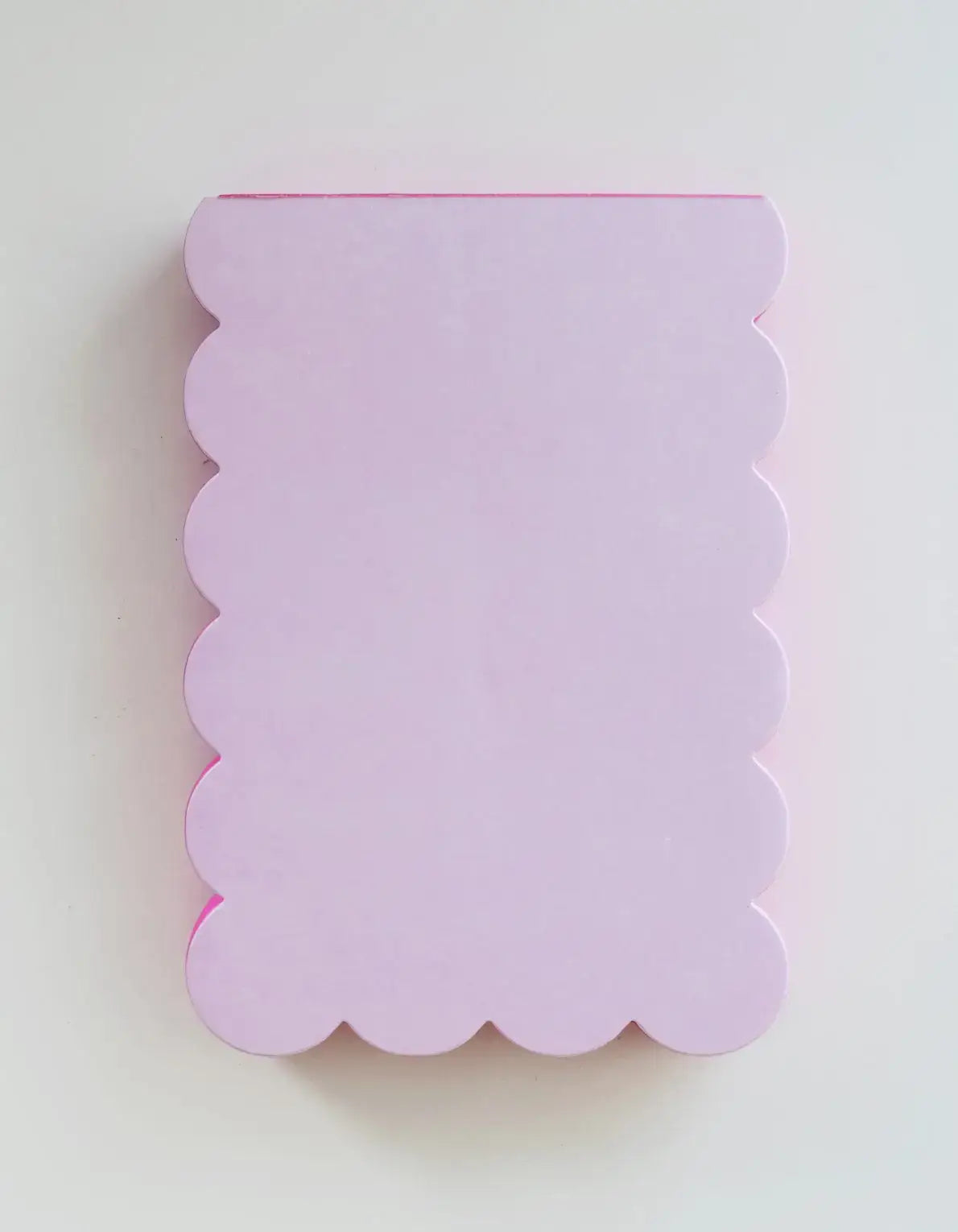Scalloped-edged lavender notebook on a white background