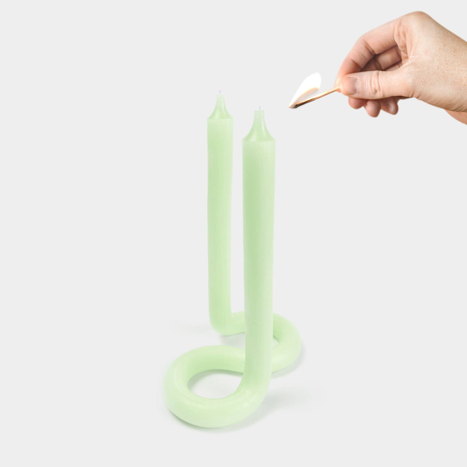 Green Twist candle showing its bent, twisted sculptural shape