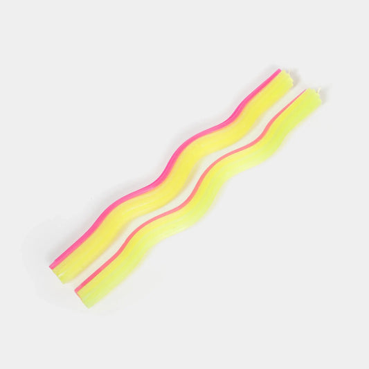 Yellow and pink wiggle taper candles showing their undulating wave shape