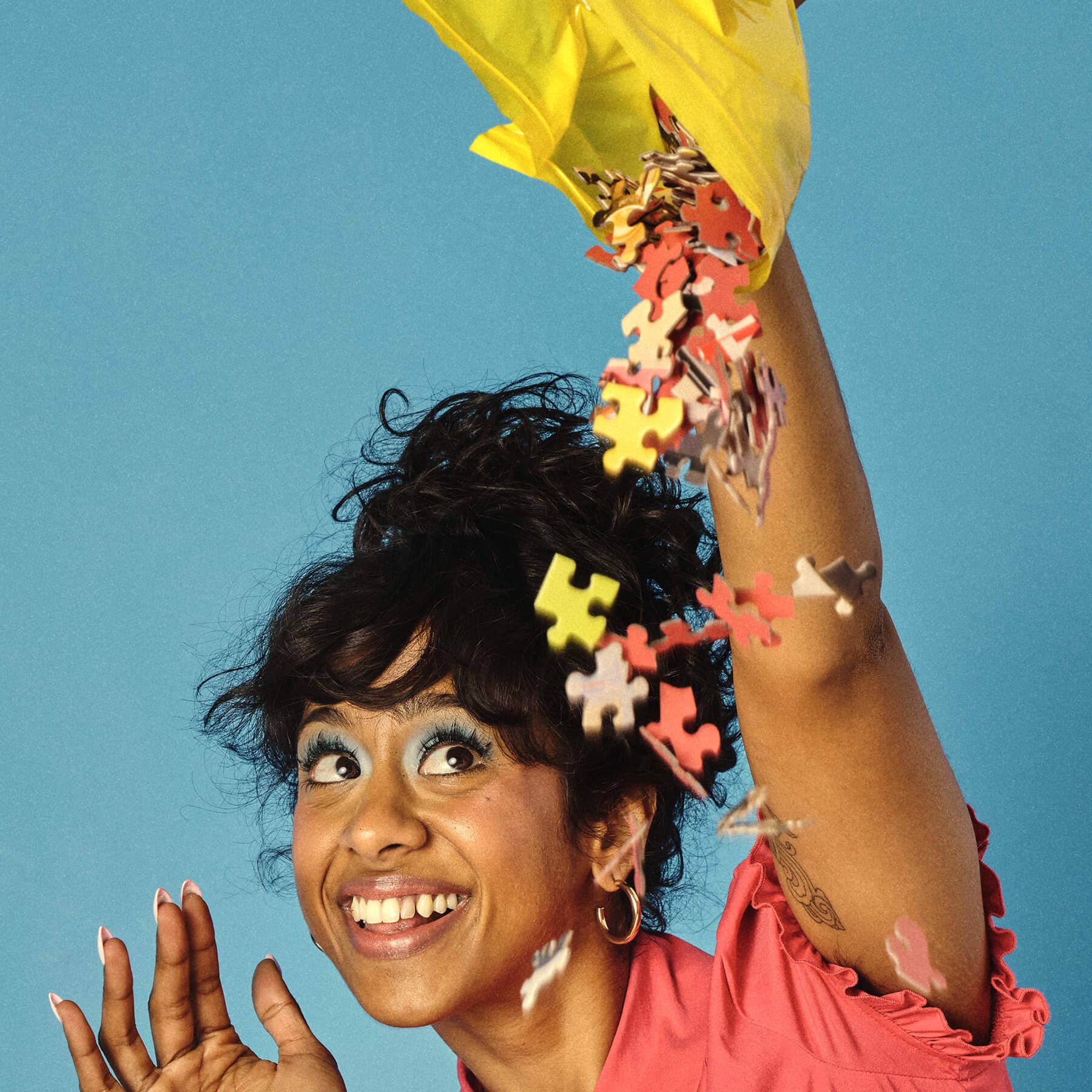 Woman with colorful puzzle pieces in her hair against a blue background