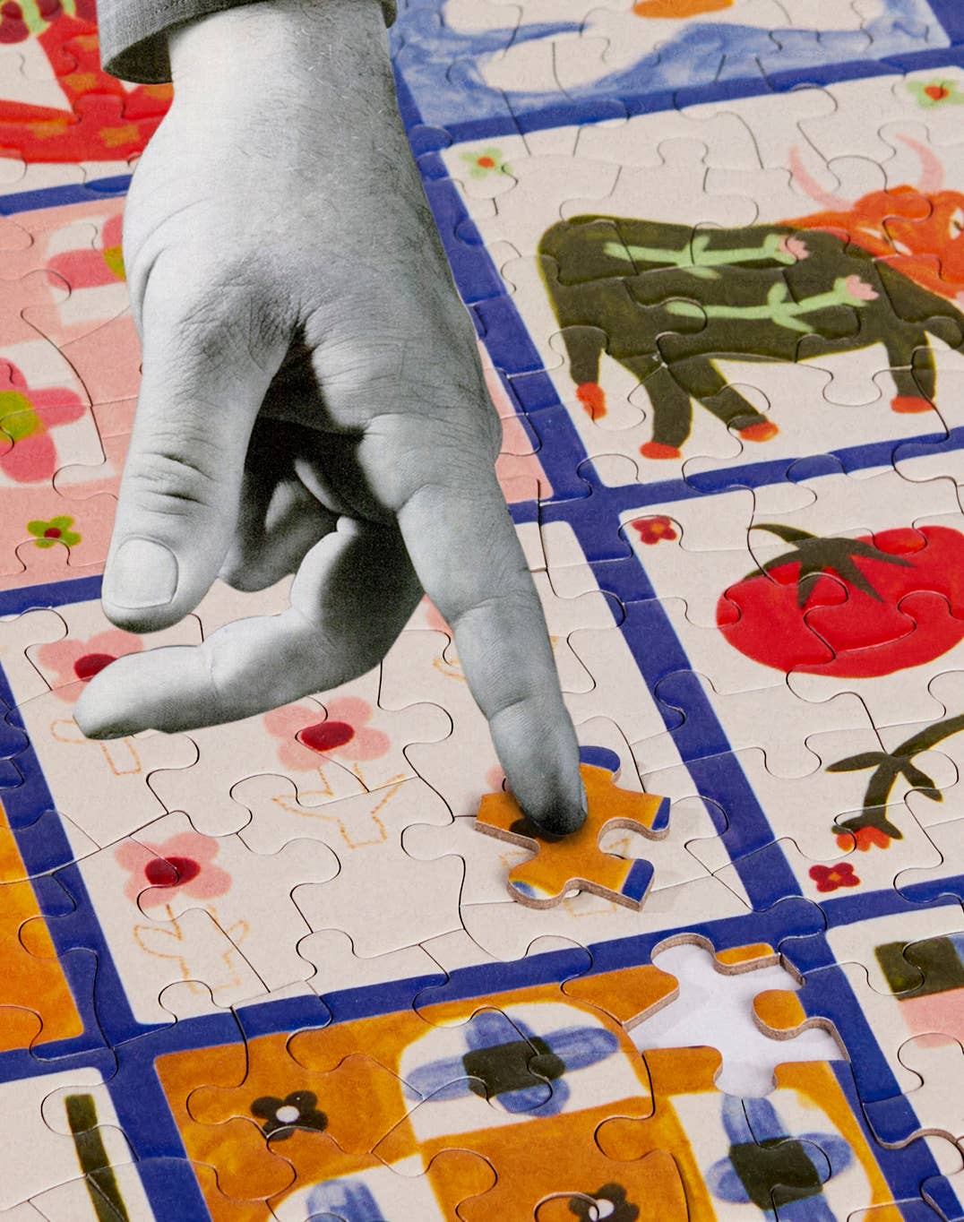 Hand pointing at a puzzle piece on a colorful puzzle