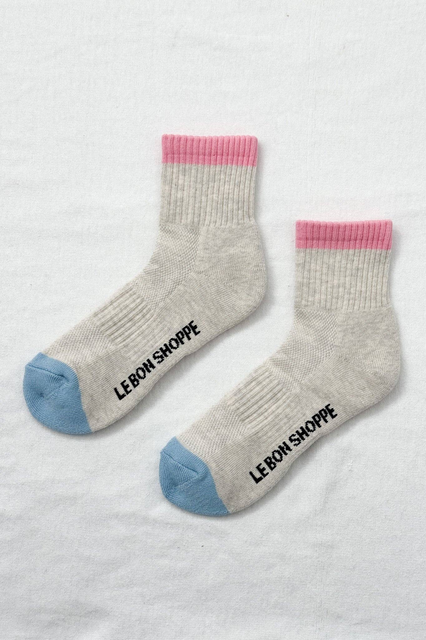 Gray socks with pink and blue accents and 'Le Bon Shoppe' branding on a light gray background