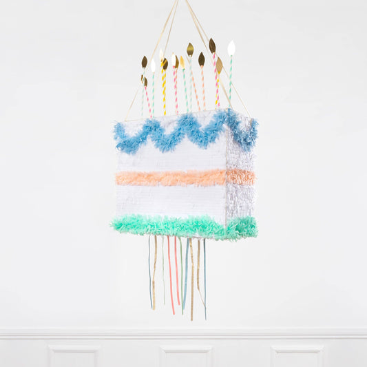 Peach, blue, and mint tissue-paper cake piñata with paper-straw candles