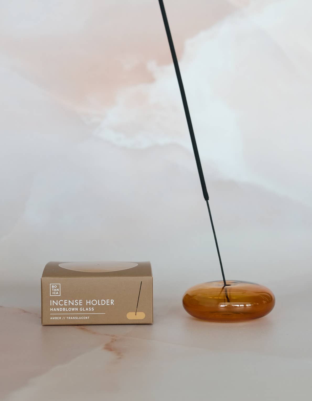 Bubble glass incense holder styled on a surface