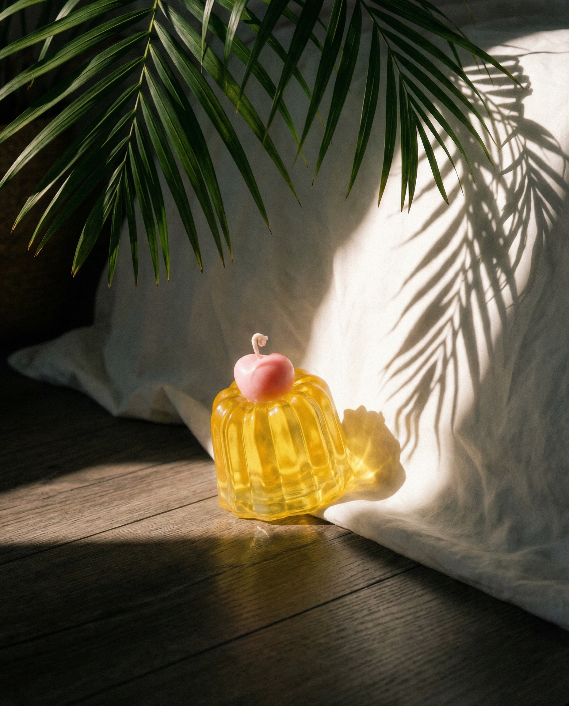 The pink cherry resting atop the yellow Chemistry Canele candle.