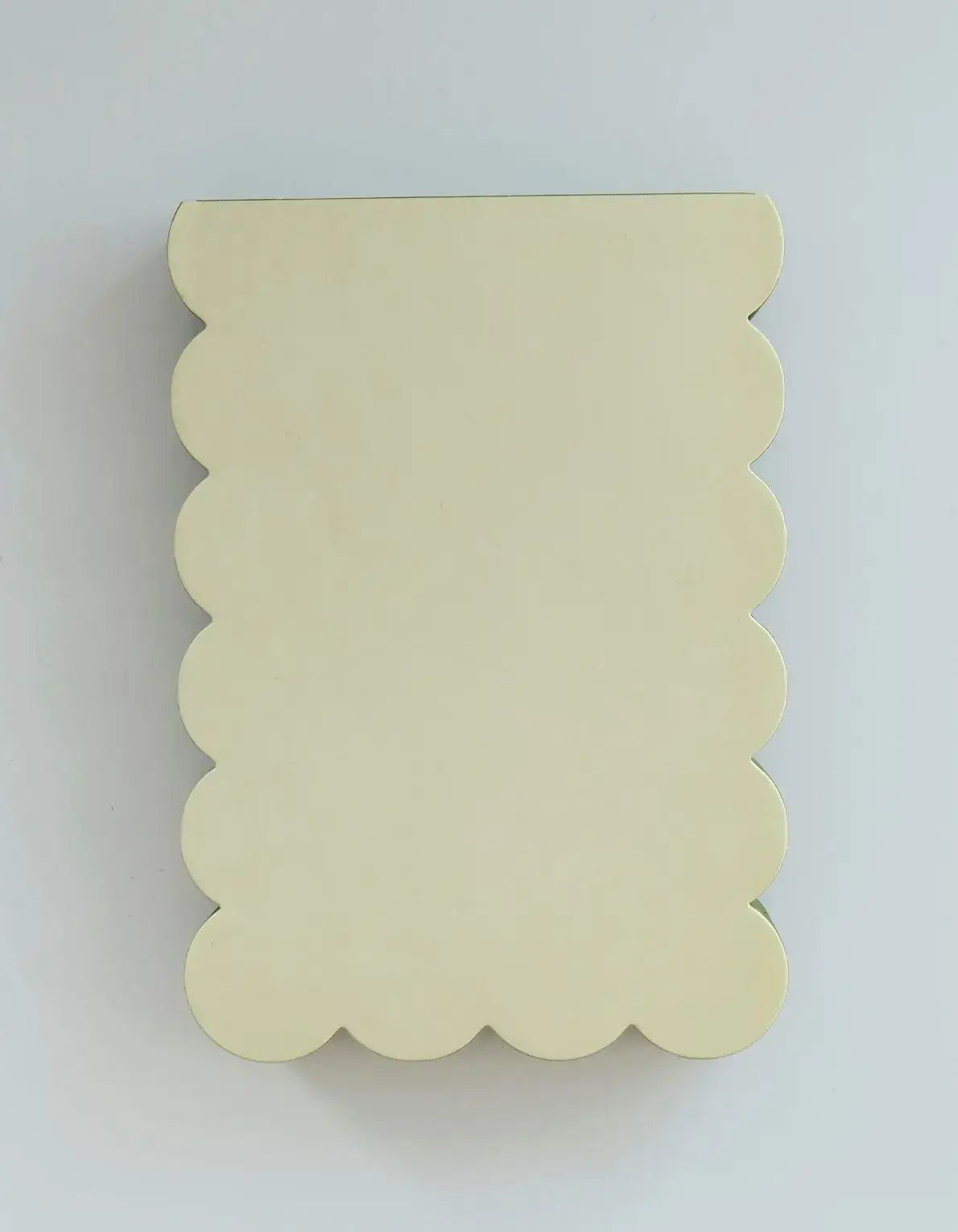 Beige scalloped-edged board on a light gray background