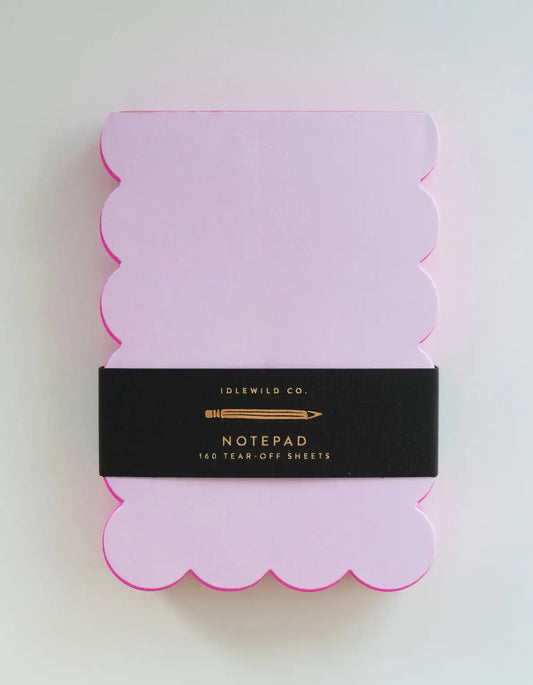 Pink scalloped notepad with black label on a white background