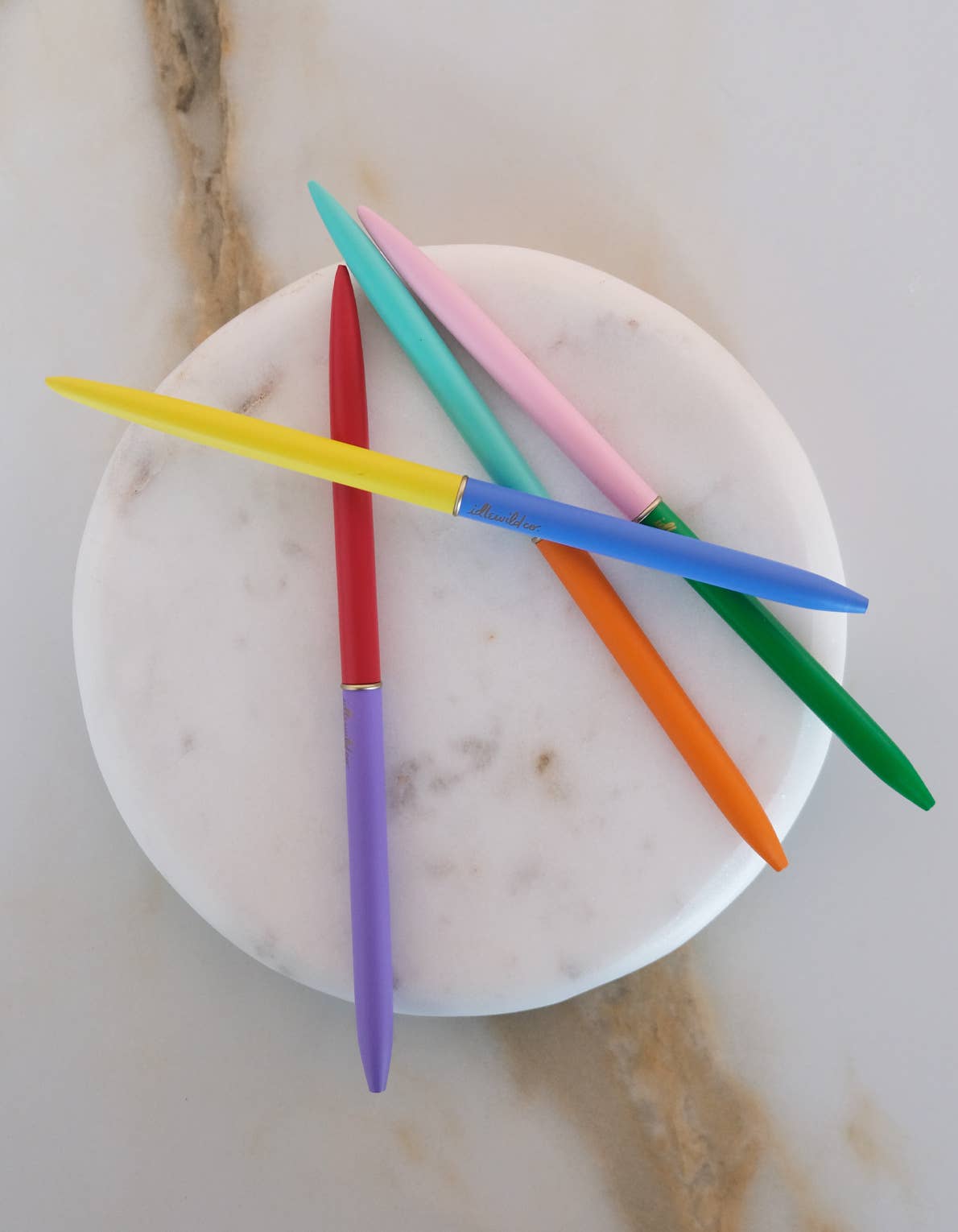 Colorful knitting needles on a marble surface