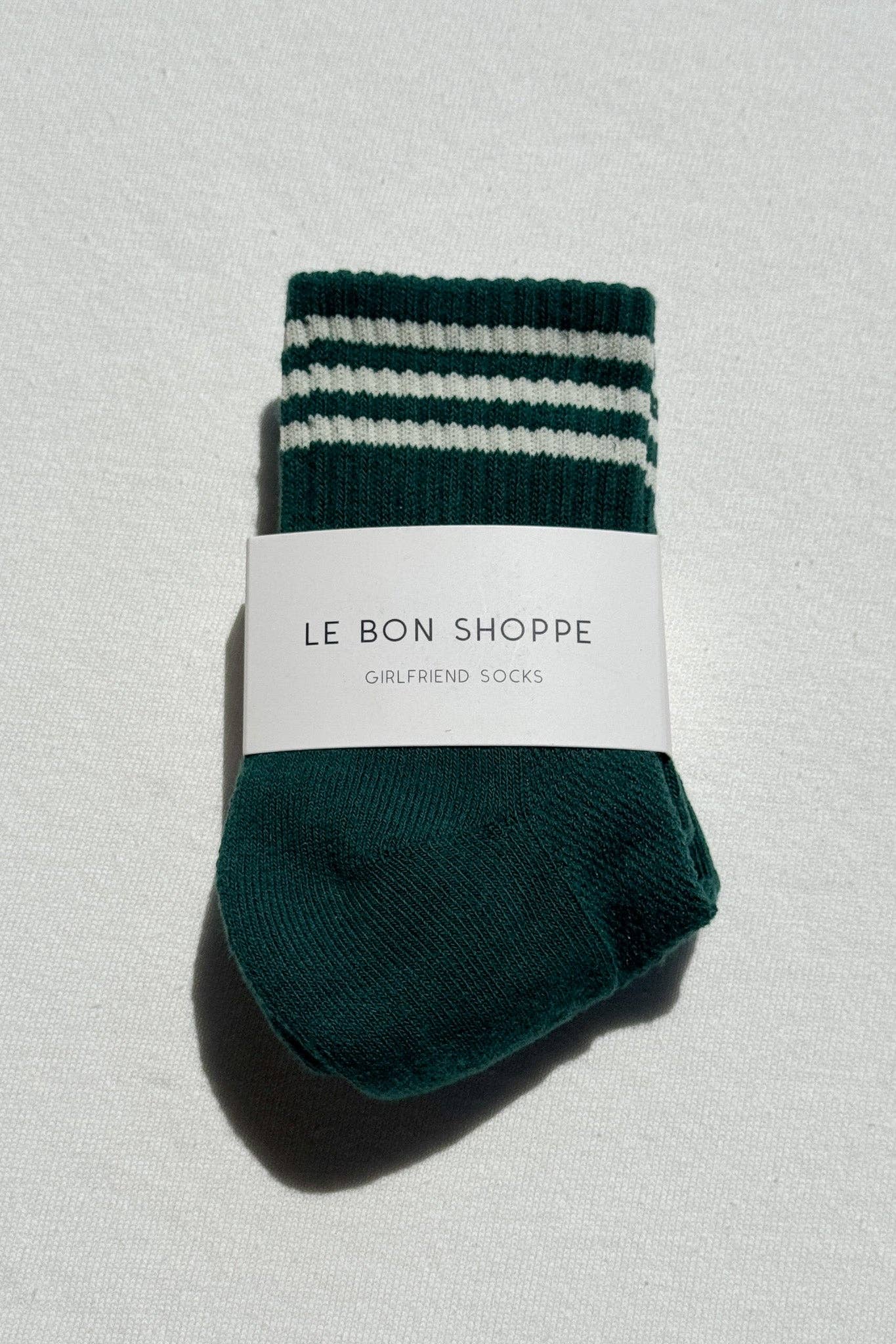 Green and white striped socks with a label on a light gray background