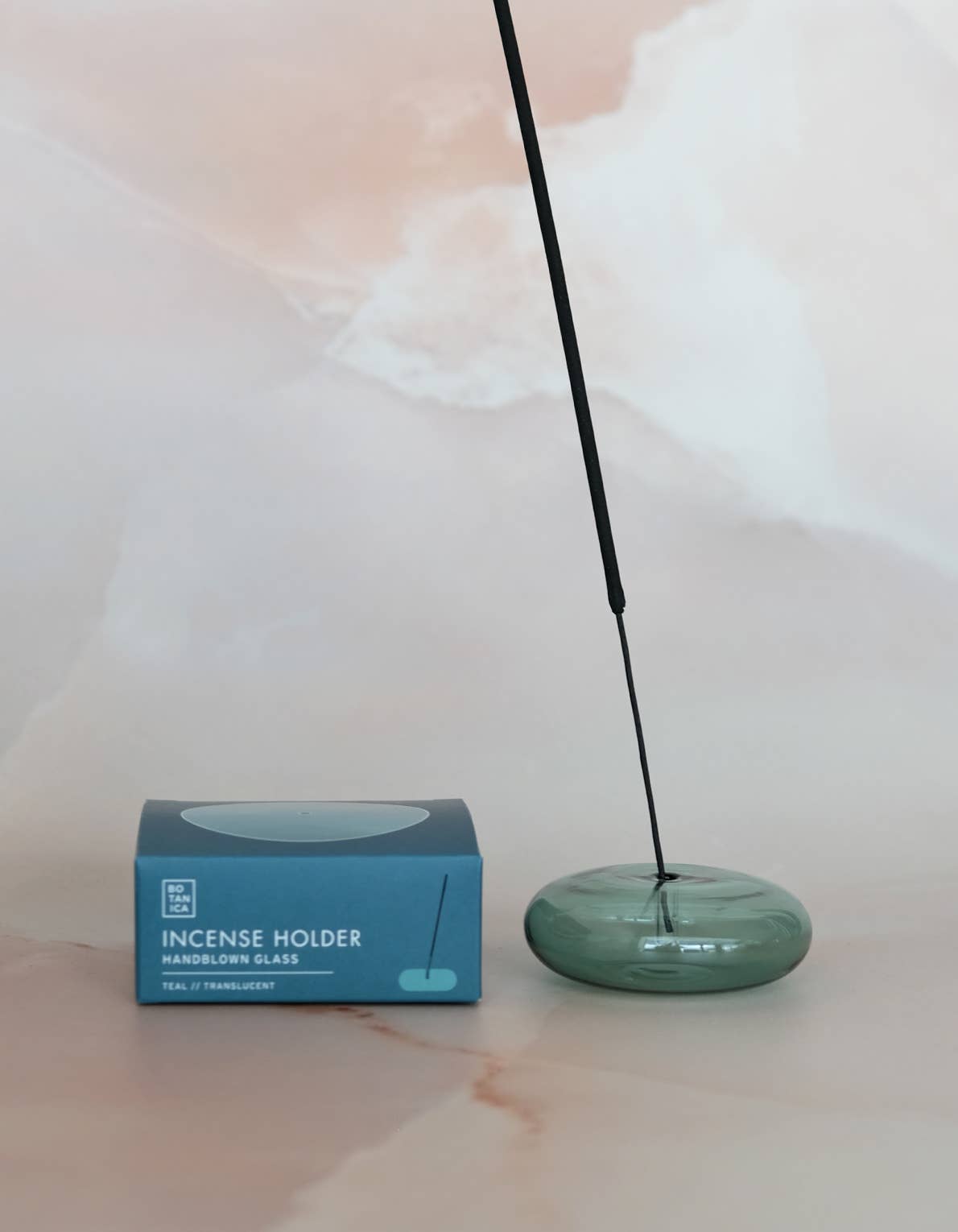 Bubble glass incense holder styled on a surface