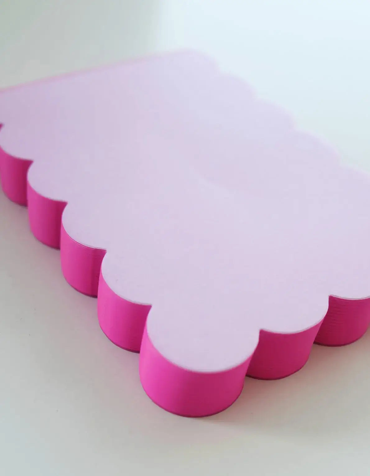 Pink and white cloud-shaped objects on a light background
