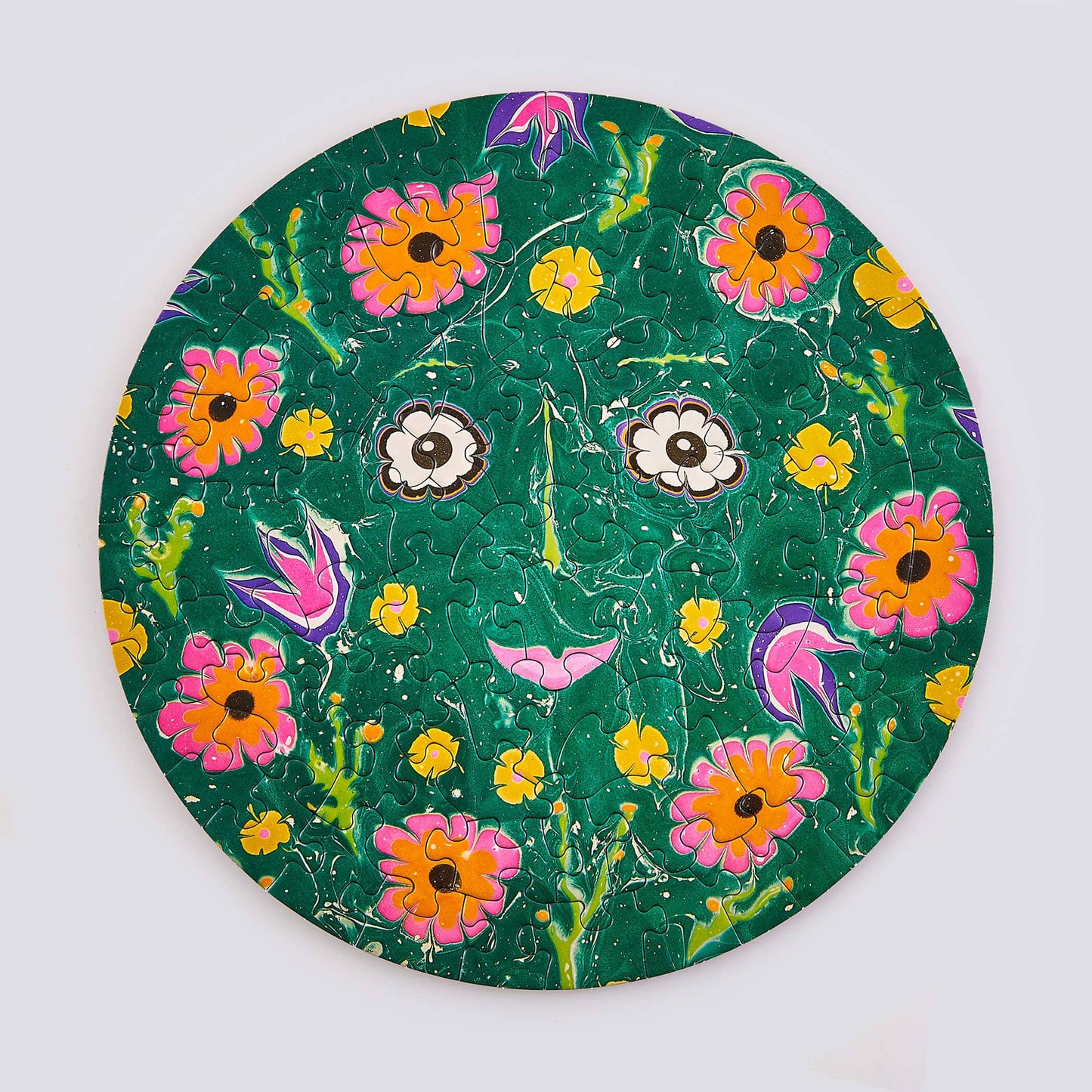 Round green puzzle with a colorful floral pattern on a white background