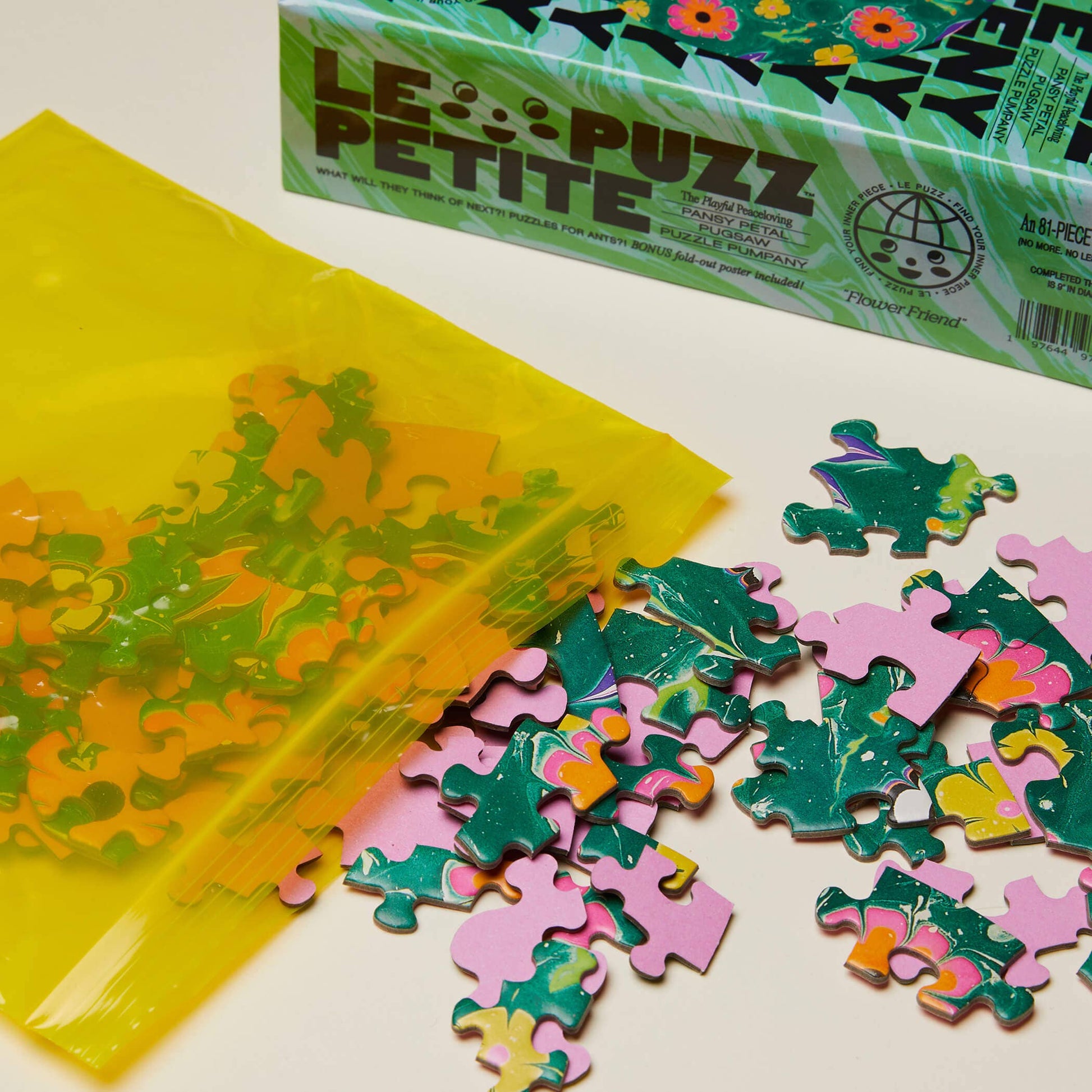 Colorful puzzle pieces and packaging on a white surface