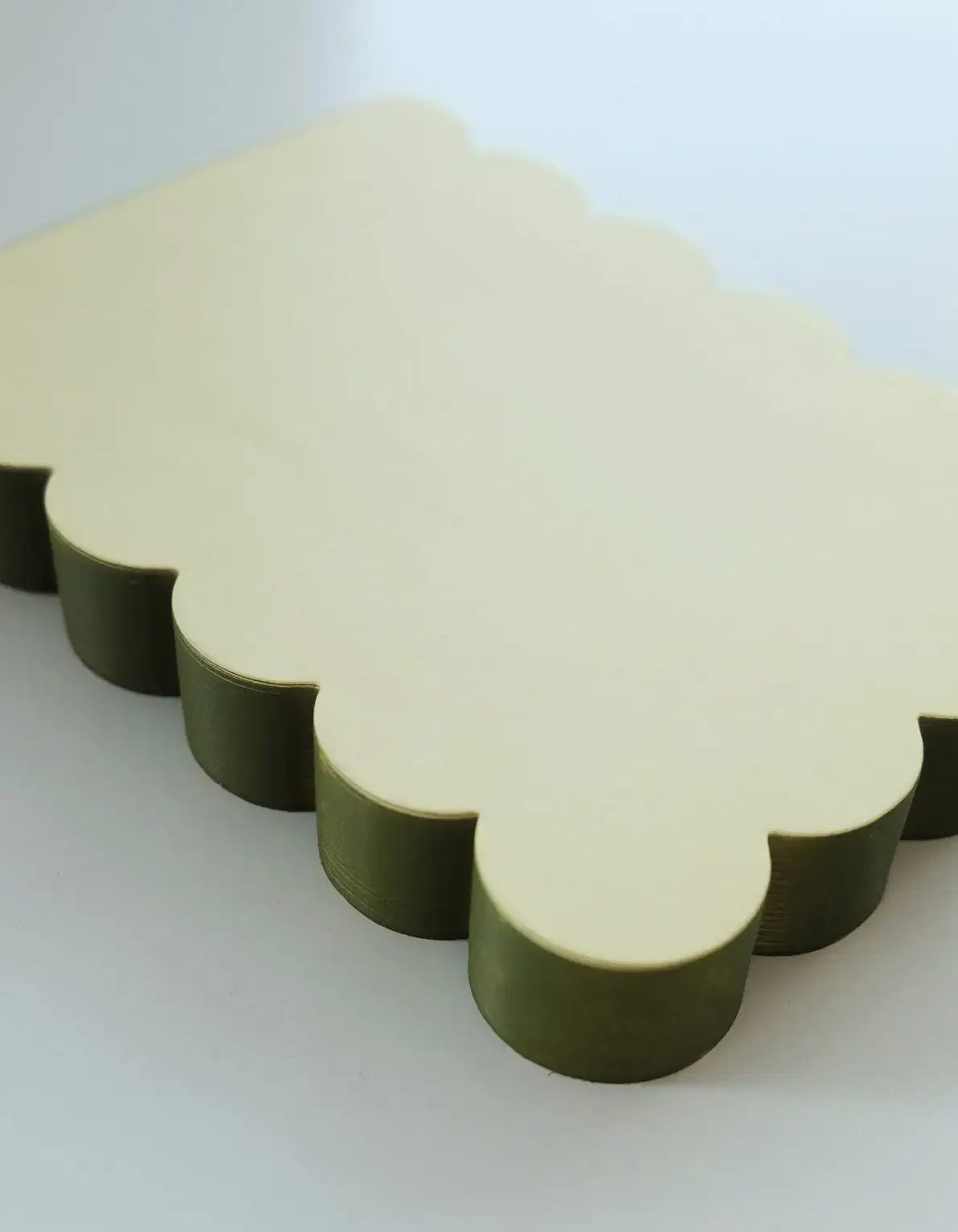 Two cloud-shaped blocks, one beige and one green, on a white background